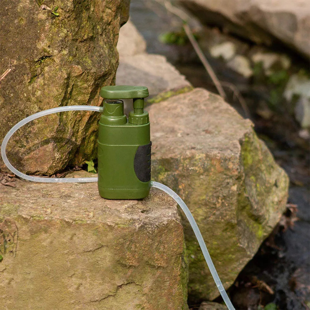 AquaVimex Portable Water Purifier on a rock with a hose, set against a natural stone background.