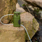 AquaVimex Portable Water Purifier on a rock with a hose, set against a natural stone background.