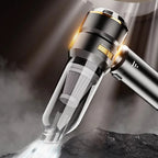 A close-up of a metallic CabinNixa Car Vacuum Cleaner with a transparent dust chamber, shown angled over a dark textured surface with smoke and light effects.