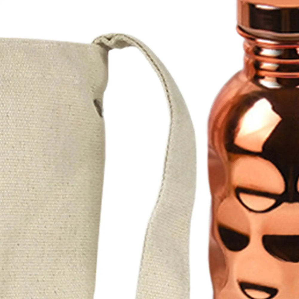 CopperSyp Copper Water Bottle with a face design on a beige pouch