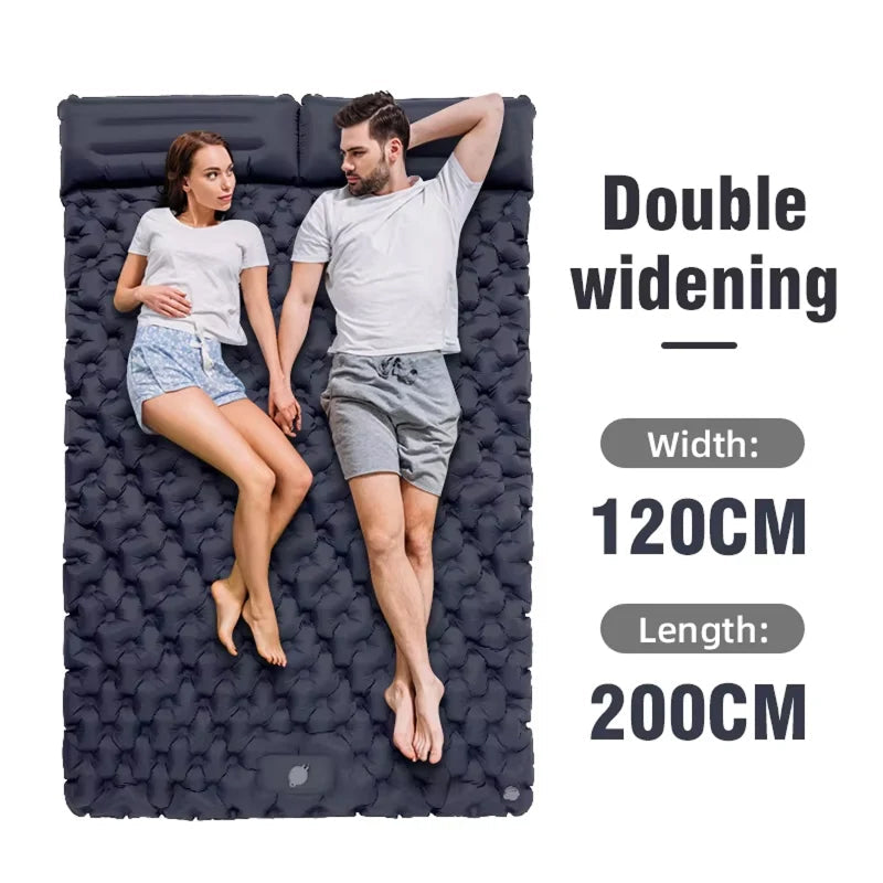 Two people lying on a large inflatable DuoRestor Pro Camping Mattress with dimensions displayed.