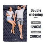 Two people lying on a large inflatable DuoRestor Pro Camping Mattress with dimensions displayed.