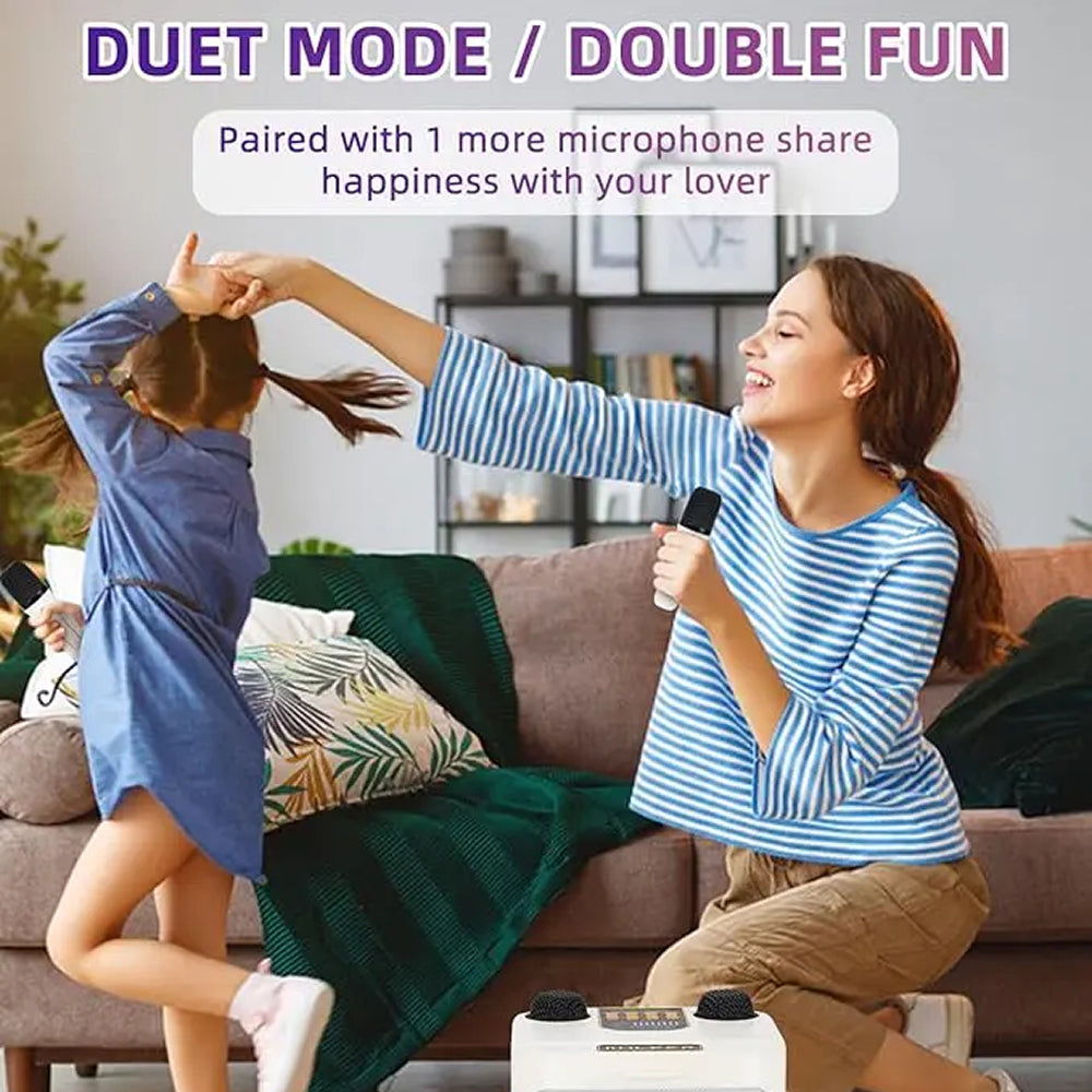 A woman and a young girl sing together in a cozy living room setup, each holding a microphone above a white dual-person FolbGent Karaoke Machine. The scene is labeled with text reading 'DUET MODE / DOUBLE FUN' and 'Paired with 1 more microphone share happiness with your lover.