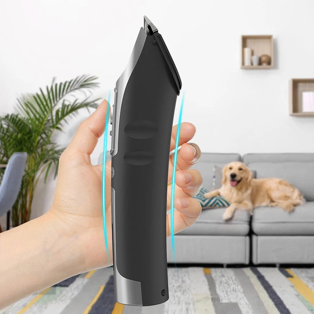 Hand holding a black and silver FuriCutx Dog Hair Clipper with a dog on a couch in the background