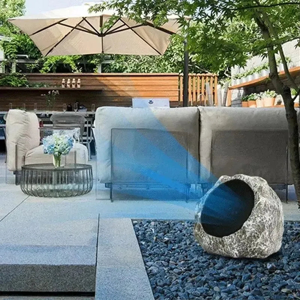 Outdoor patio setting with a stone water feature and umbrella