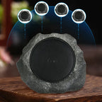 Rock-like speaker with four embedded speakers on a wooden surface