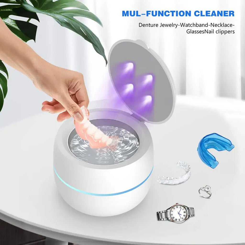 Multifunctional OsicClear Ultrasonic Retainer Cleaner with a hand placing an item into it, surrounded by jewelry and a watch.