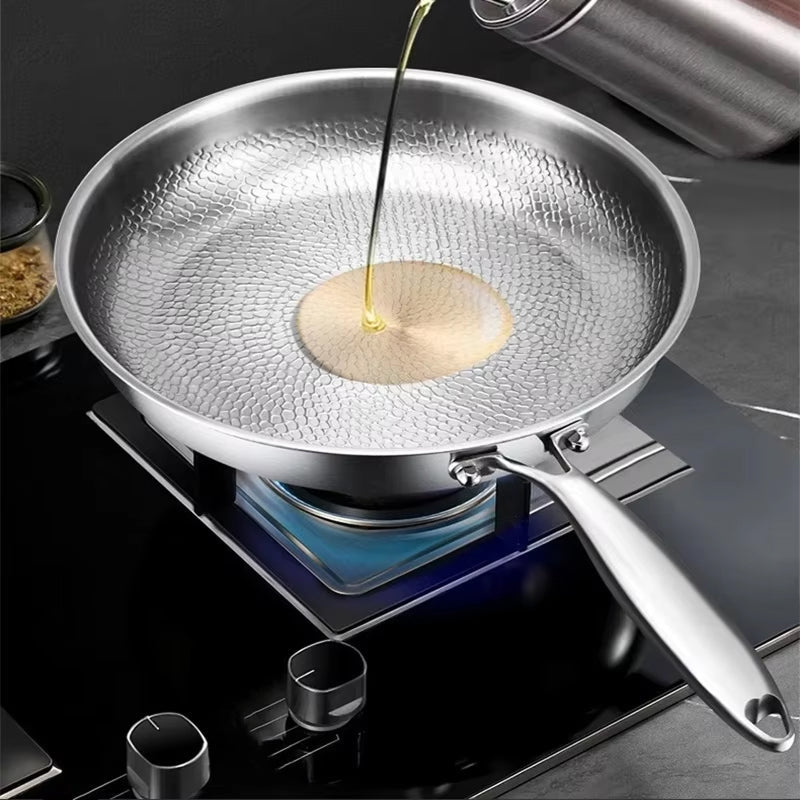 TikaxPan Titanium Frying Pan on a stove with oil being poured onto a pancake.