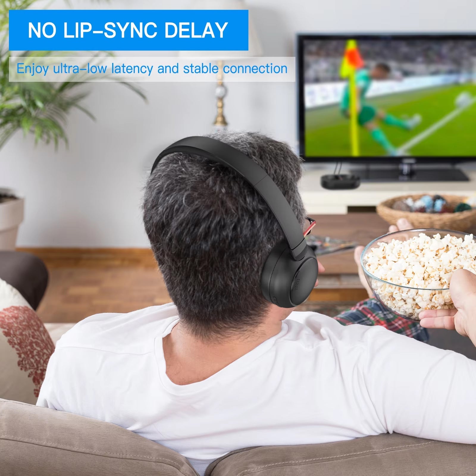 Person wearing Tiverno TV Headphones and eating popcorn while watching TV in a living room.