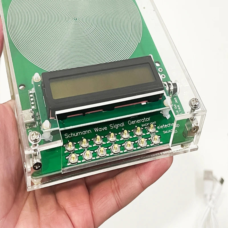 Schumann Wave VanotCine Frequency Generator held in a hand with a white background