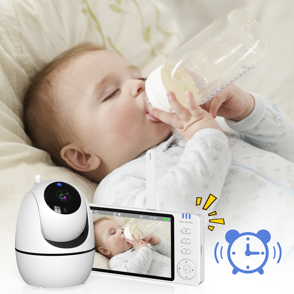 Baby lying on a bed drinking from a bottle with a Wavel Baby Monitor displaying the video feed.
