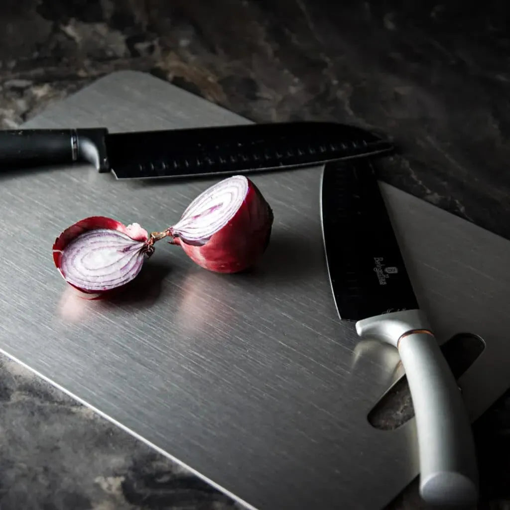 Sliced red onion on a Wavel Titanium Cutting Board with two knives.